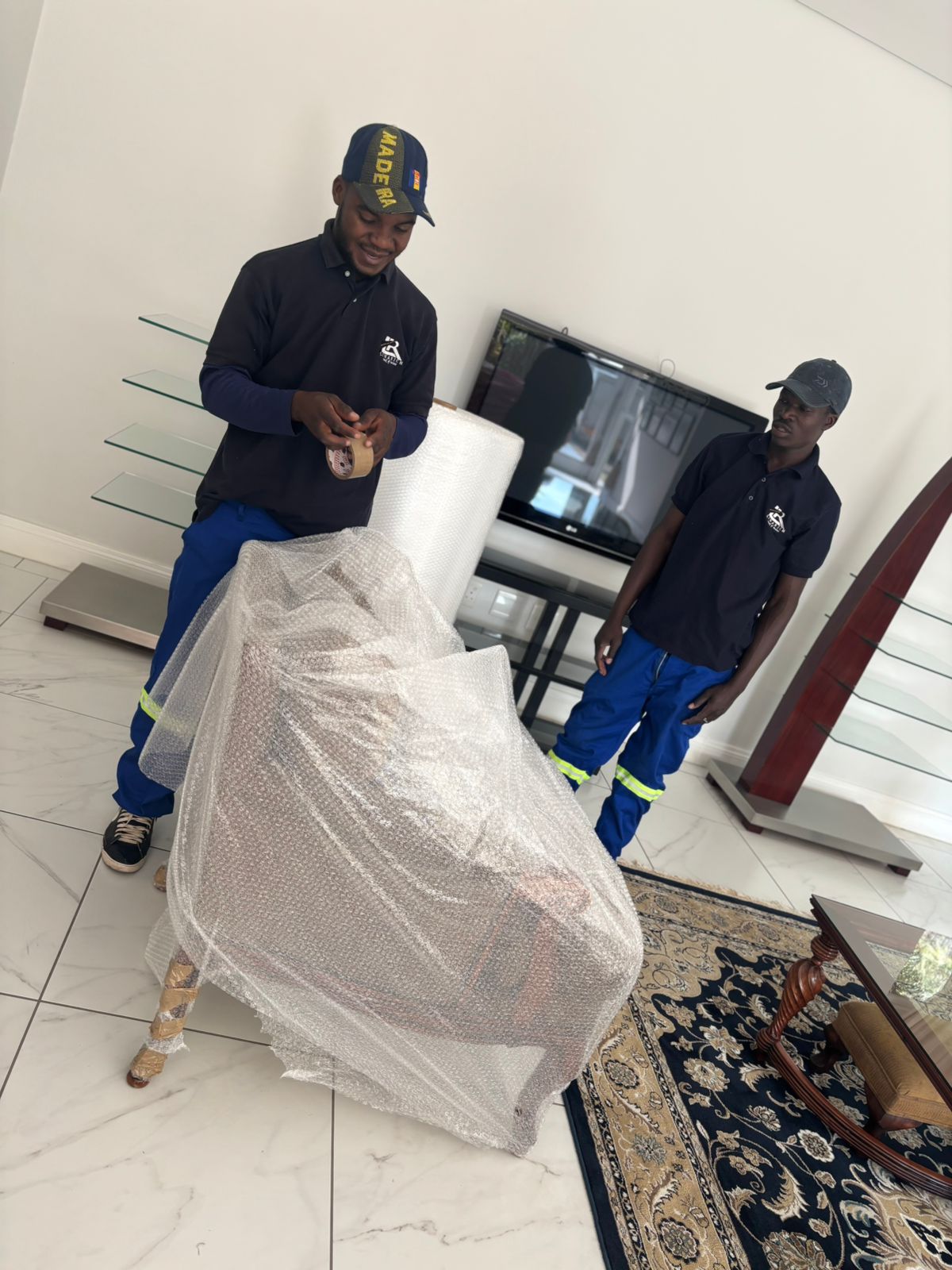 Professional furniture movers carrying sofa in Cape Town home relocation